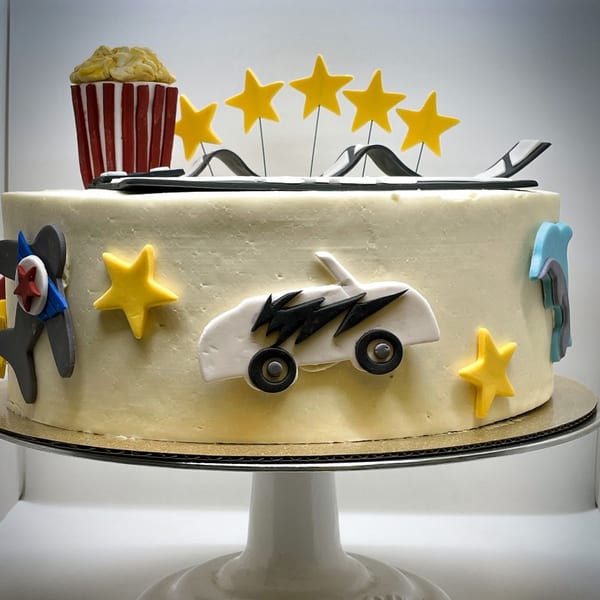Bonjour Bakery & Bistro cake decorated with a popcorn bucket, stars, car, and airplane.